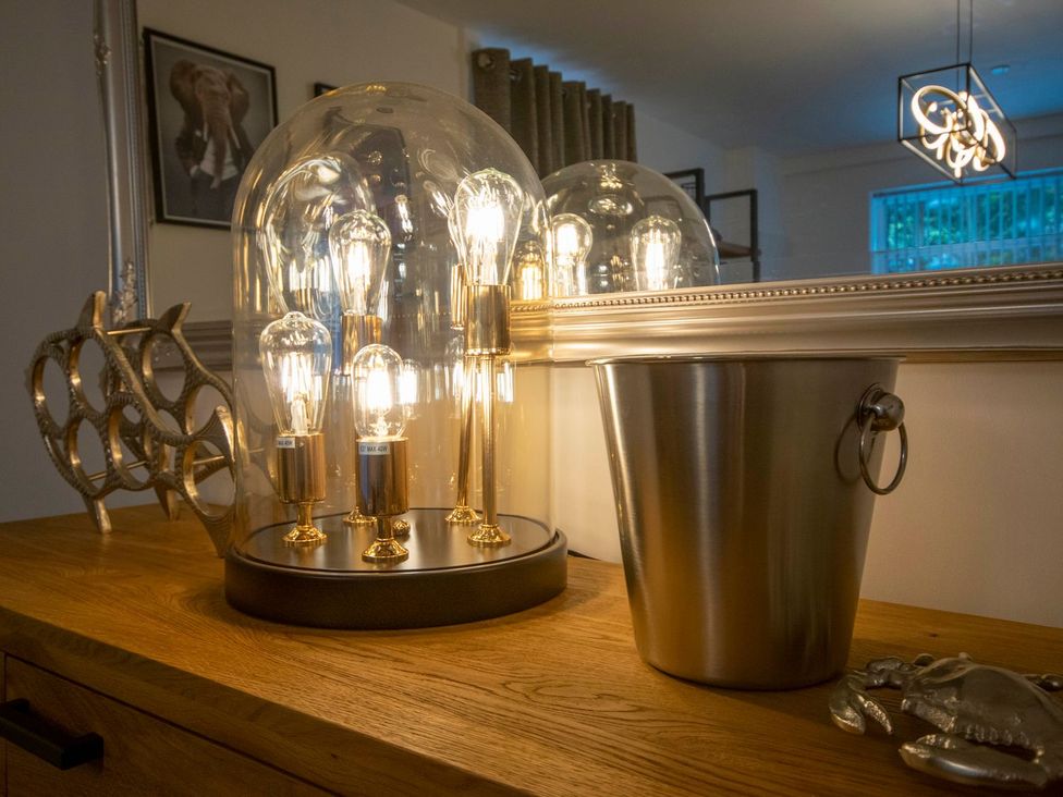 A light fixture and bucket on a table at Seagull Shack in Morfa Bychan