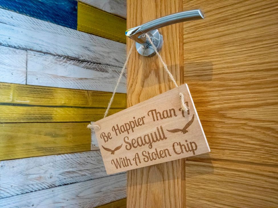 A door with a wooden sign at Seagull Shack in Morfa Bychan