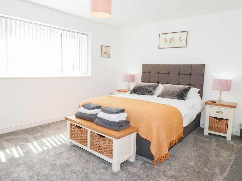 A bedroom with a bed and bedside tables at Seagull Shack Morfa Bychan