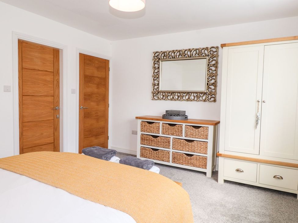 A bedroom with a bed and dresser at Seagull Shack in Morfa Bychan