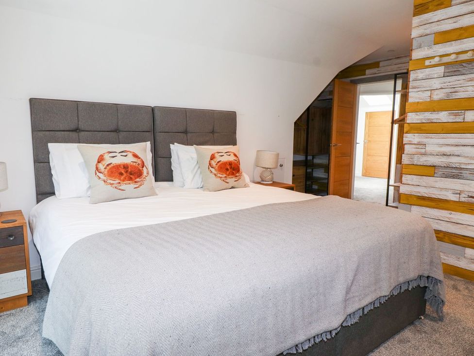 A bedroom with a bed and bedside table at Seagull Shack Morfa Bychan