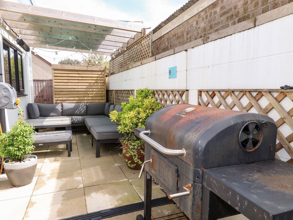 An outdoor area with a grill and seating at Seagull Shack Morfa Bychan