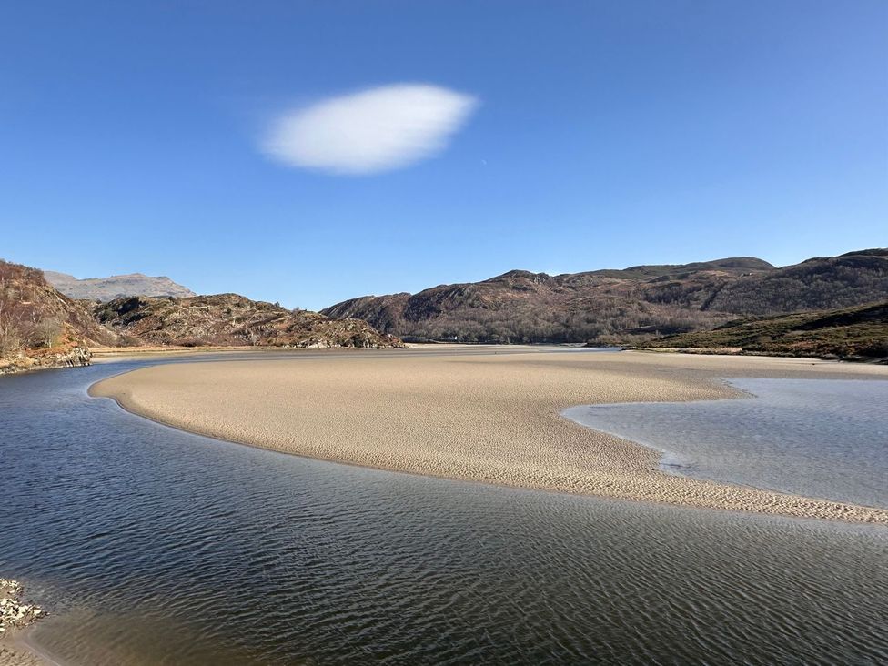 A river with a sandbank and mountains in the background at Seagull Shack Morfa Bychan