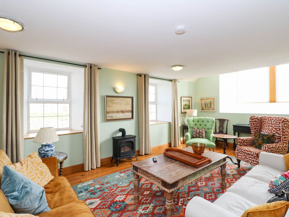 A living room with several seating areas at the Old School House Isle Of South Uist
