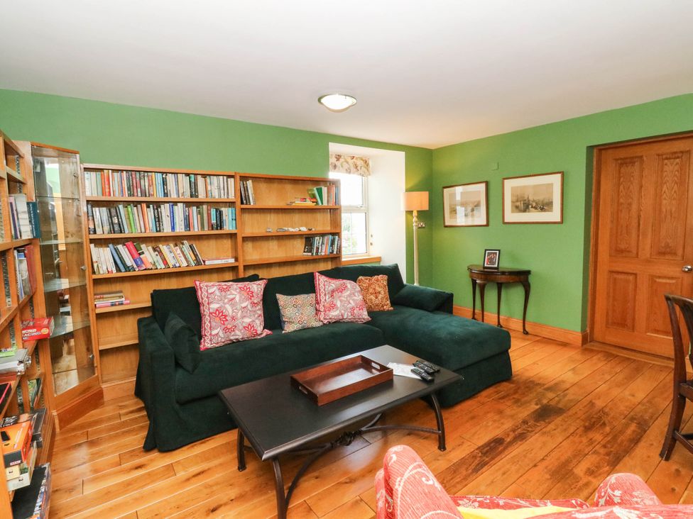 A sitting room with a sofa and bookshelf at Old School House Isle Of South Uist