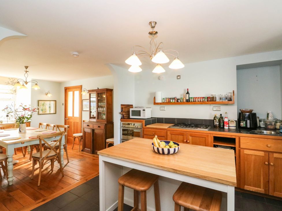A kitchen with dining table and cabinets at Old School House Isle Of South Uist