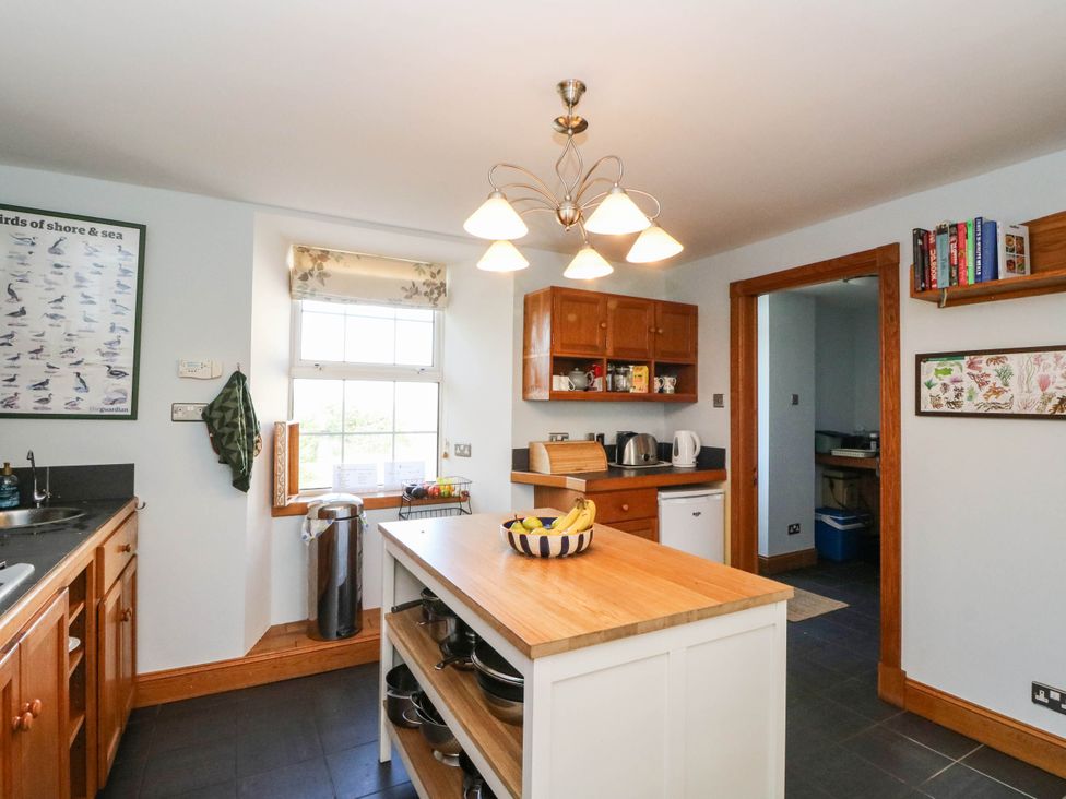 A kitchen with a central island and kitchen cabinets at Old School House Isle Of South Uist