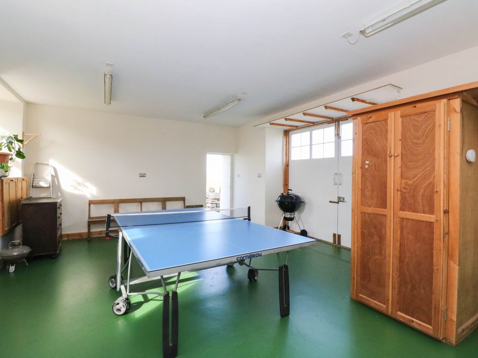 A games room with a table tennis table and cabinets at Old School House Isle Of South Uist