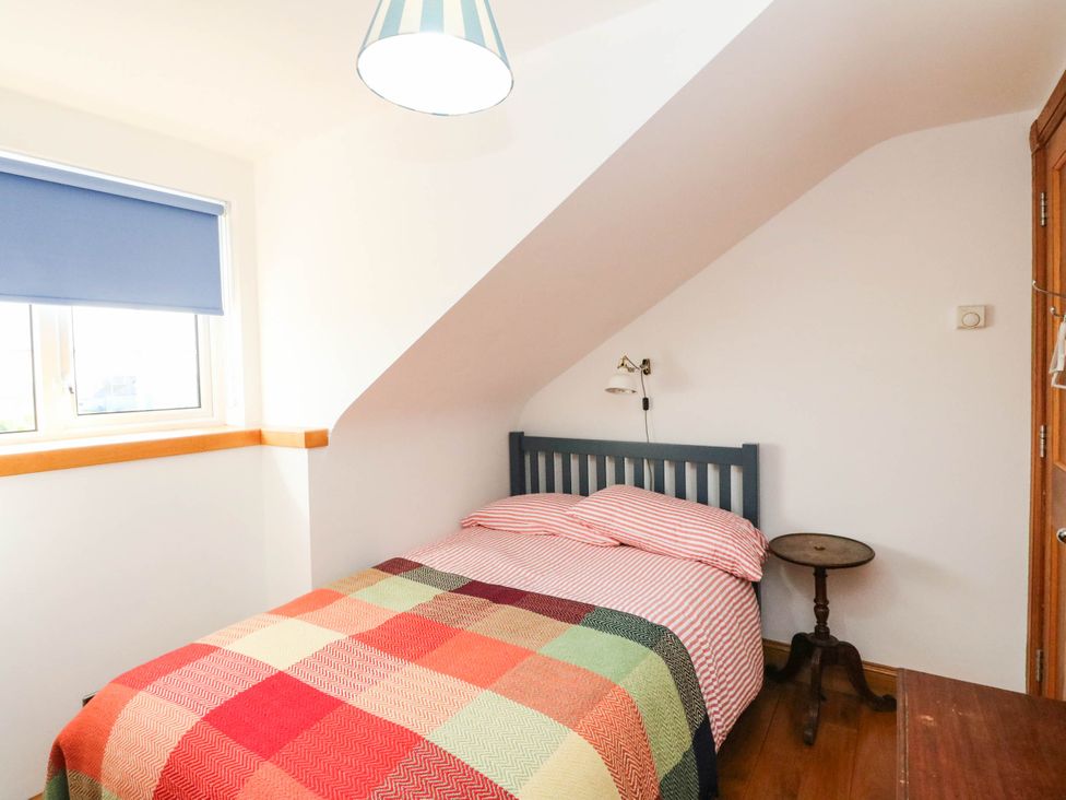A bedroom with a bed and bedside table at Old School House Isle Of South Uist