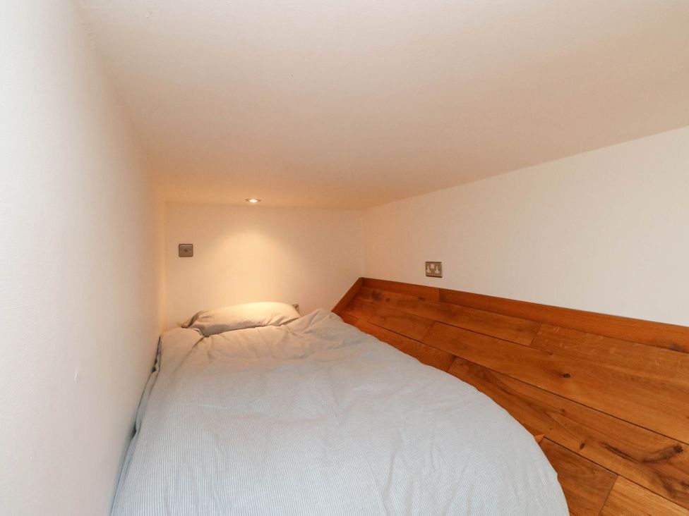 A bedroom with a bed and light fixture at Old School House Isle Of South Uist