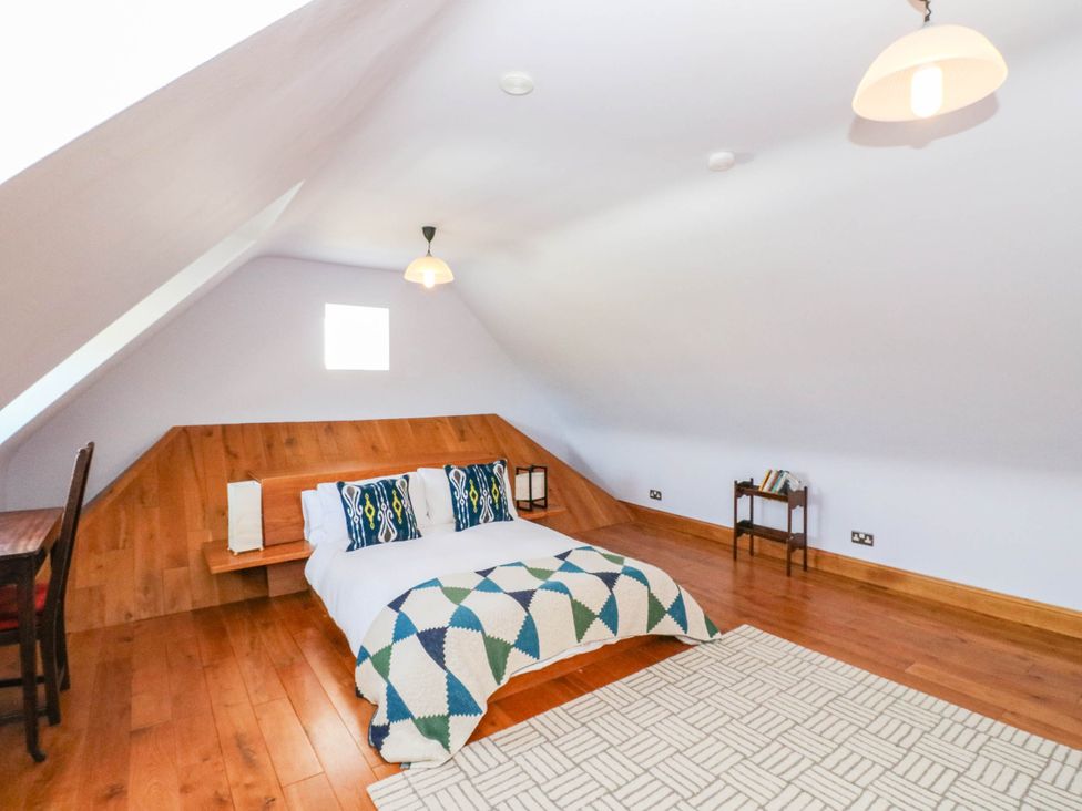 A bedroom with a bed and shelf at The Old School House Isle Of South Uist