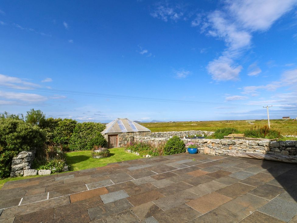 An outdoor area with a stone patio and a shed at Old School House Isle Of South Uist