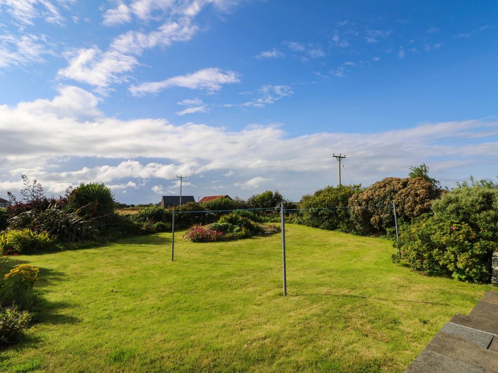 A garden with grass and a clothesline at The Old School House in Isle Of South Uist