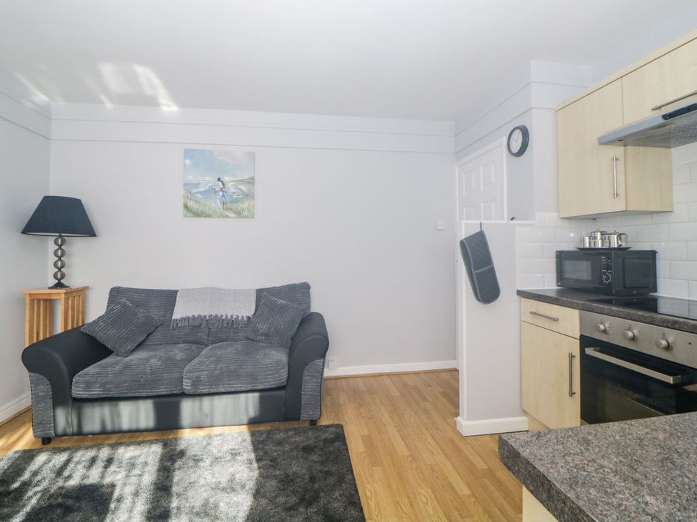 A living room with a sofa and lamp at Devon Seaside Apartment in Paignton