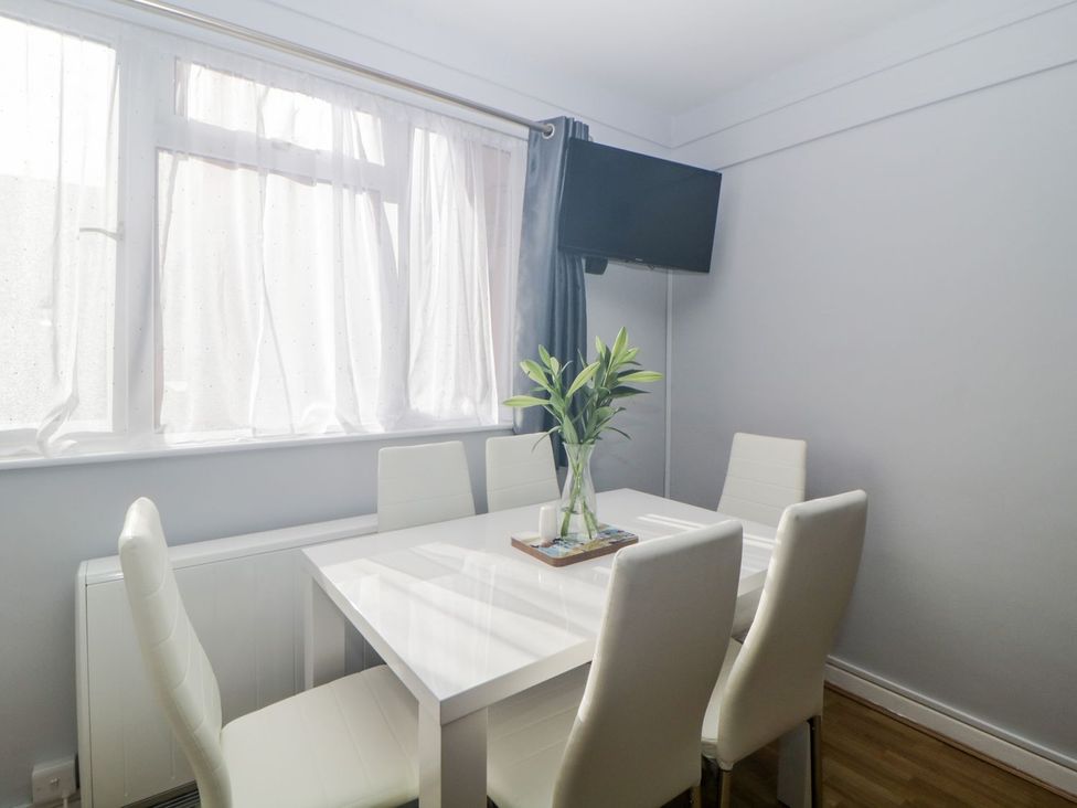 A dining room with a table and chairs at Devon Seaside Apartment in Paignton