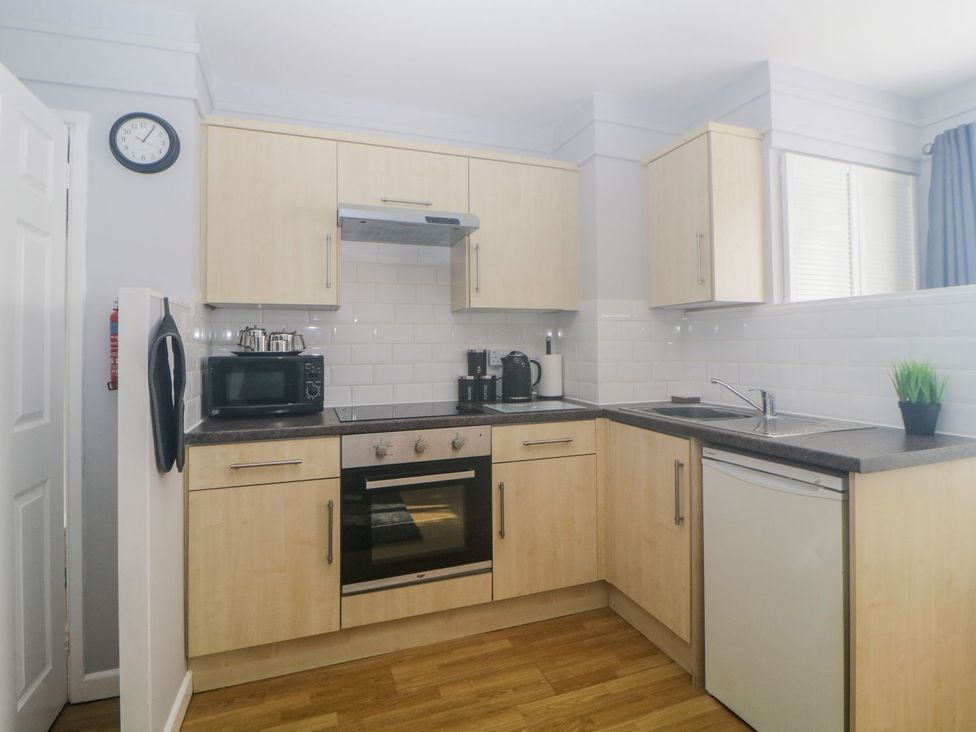 A kitchen with cabinets and appliances at Devon Seaside Apartment Paignton