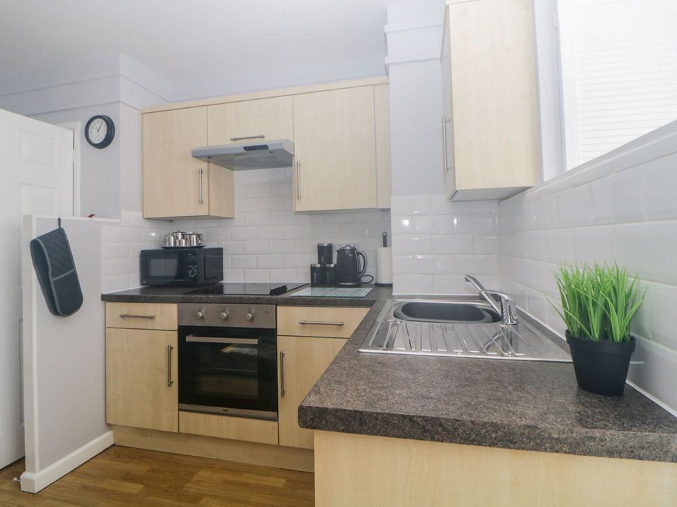 A kitchen with appliances and a sink at Devon Seaside Apartment in Paignton