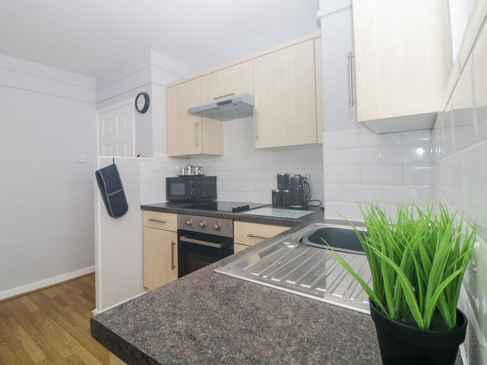 A kitchen with countertop, cabinets, microwave, and sink at Devon Seaside Apartment in Paignton