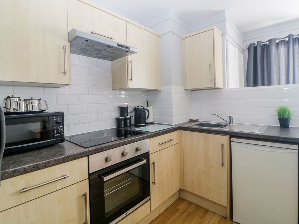 A kitchen with a sink, oven, and microwave at Devon Seaside Apartment Paignton