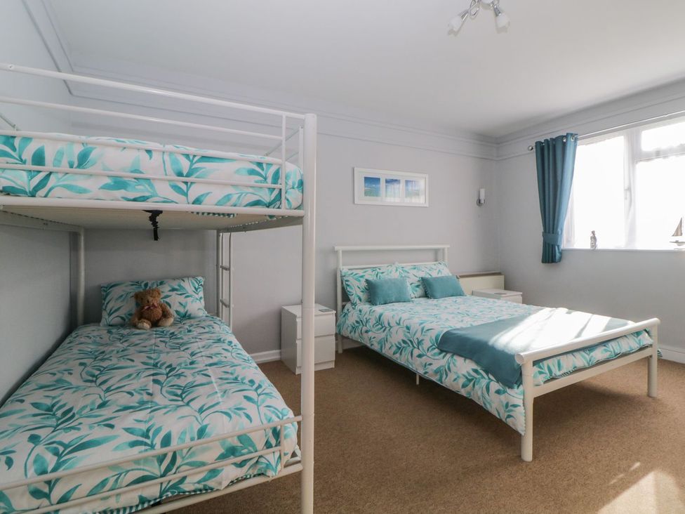 A bedroom with a bunk bed and a double bed at Devon Seaside Apartment Paignton