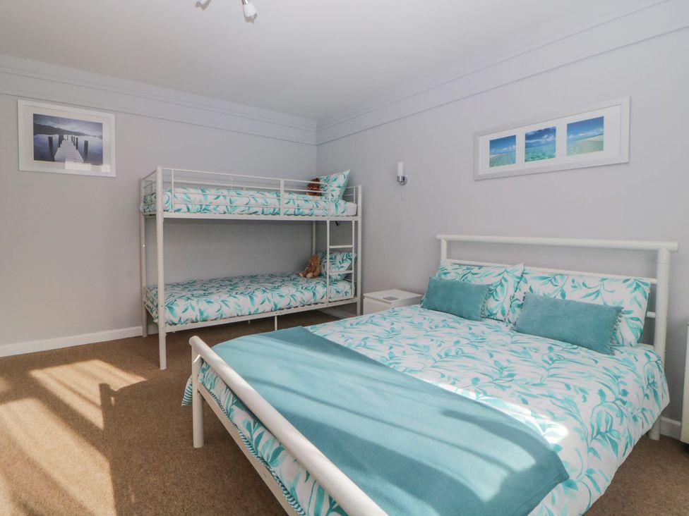 A bedroom with a bunk bed and a double bed at Devon Seaside Apartment in Paignton