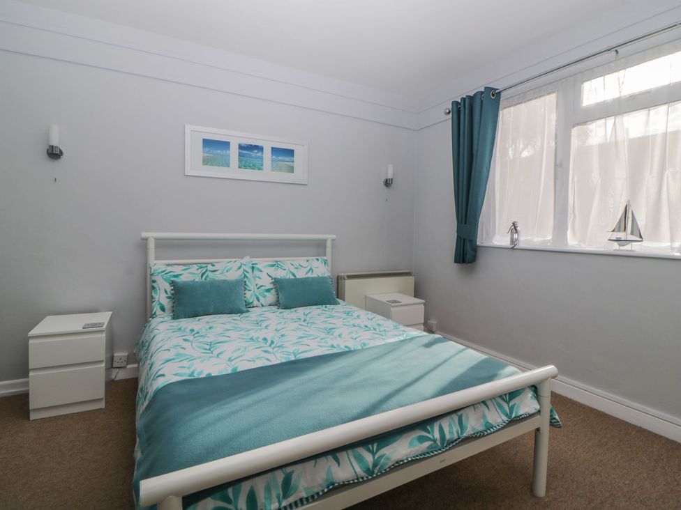 A bedroom with a bed and bedside table at Devon Seaside Apartment in Paignton