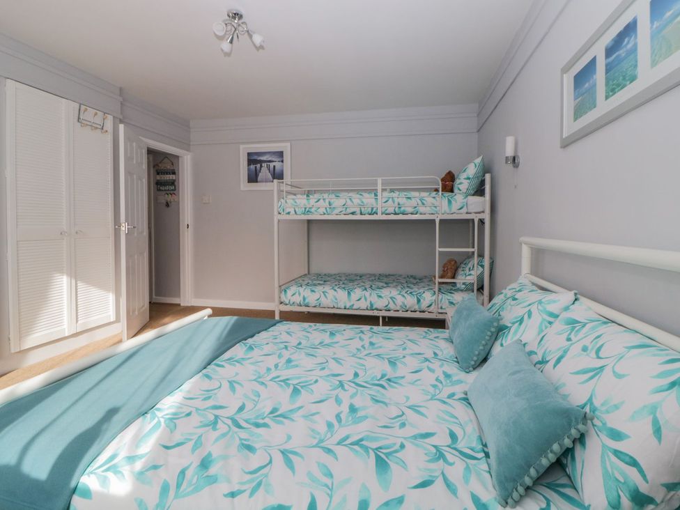 A bedroom with a bunk bed and a double bed at Devon Seaside Apartment in Paignton