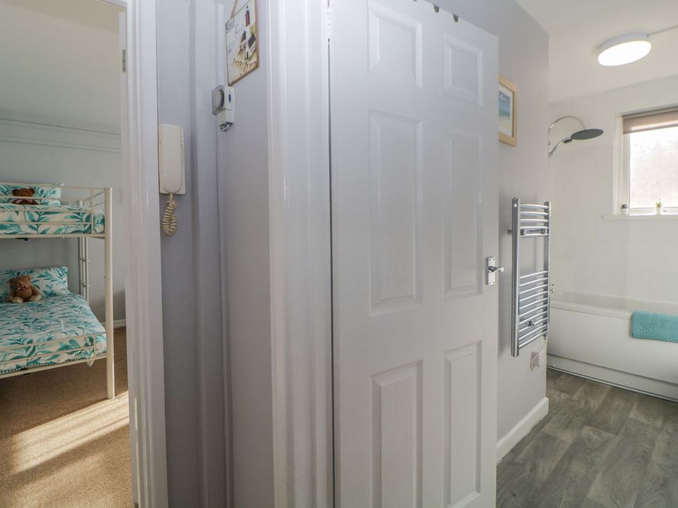 A bathroom with a bathtub and a bunk bed at Devon Seaside Apartment Paignton