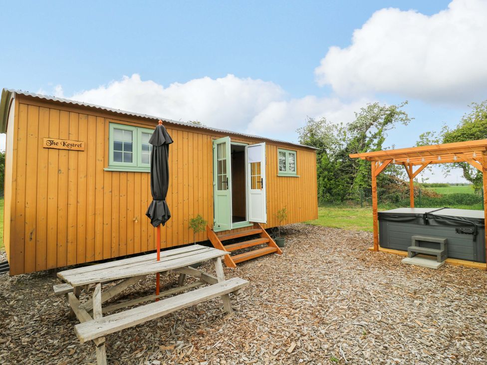 A cabin with a hot tub and picnic table at The Kestrel in Cambridge
