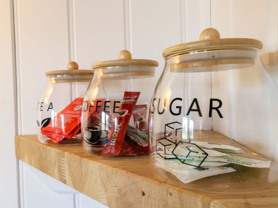 A kitchen shelf with jars labelled tea, coffee, and sugar at The Kestrel in Cambridge