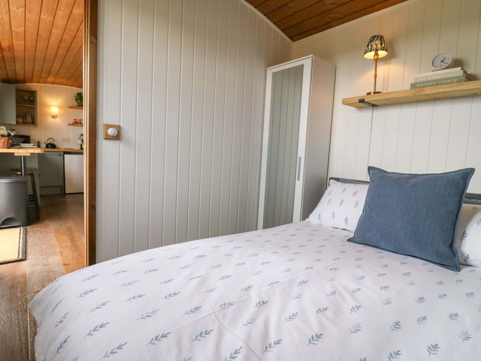 A bedroom with a bed and a wardrobe at The Kestrel in Cambridge