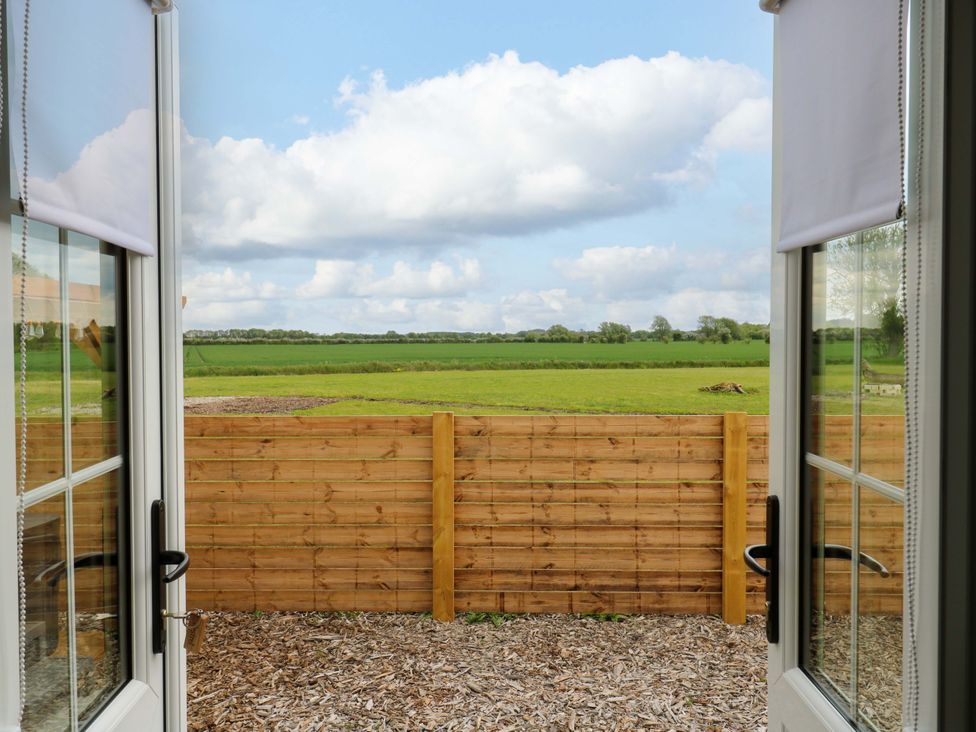 View from a window showing a field and wooden fence at The Kestrel in Cambridge