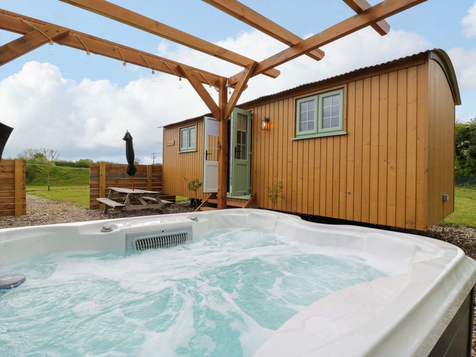 A hot tub next to a wooden shed at The Kestrel in Cambridge