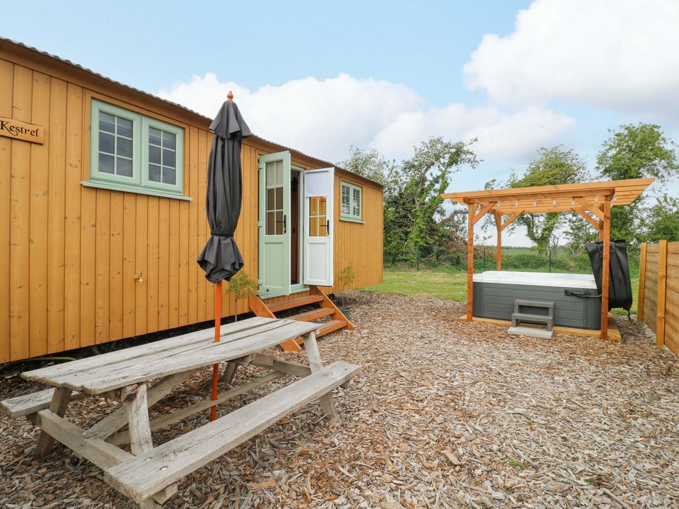 An outdoor area with a wooden cabin and hot tub at The Kestrel in Cambridge