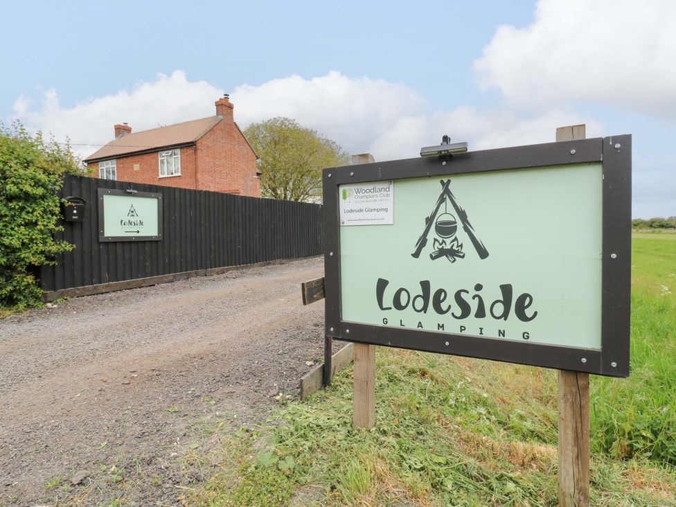 A Lodeside Glamping sign at the entrance of the property at The Kestrel in Cambridge