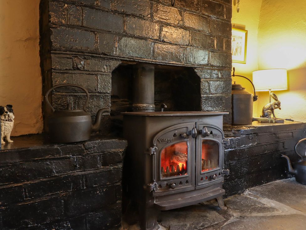 A living room with a stove and kettle at Frondirion in Dinas Mawddwy