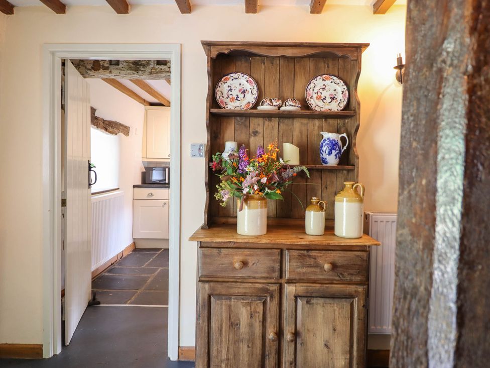 A kitchen with a wooden cabinet and decorative items at Frondirion in Dinas Mawddwy