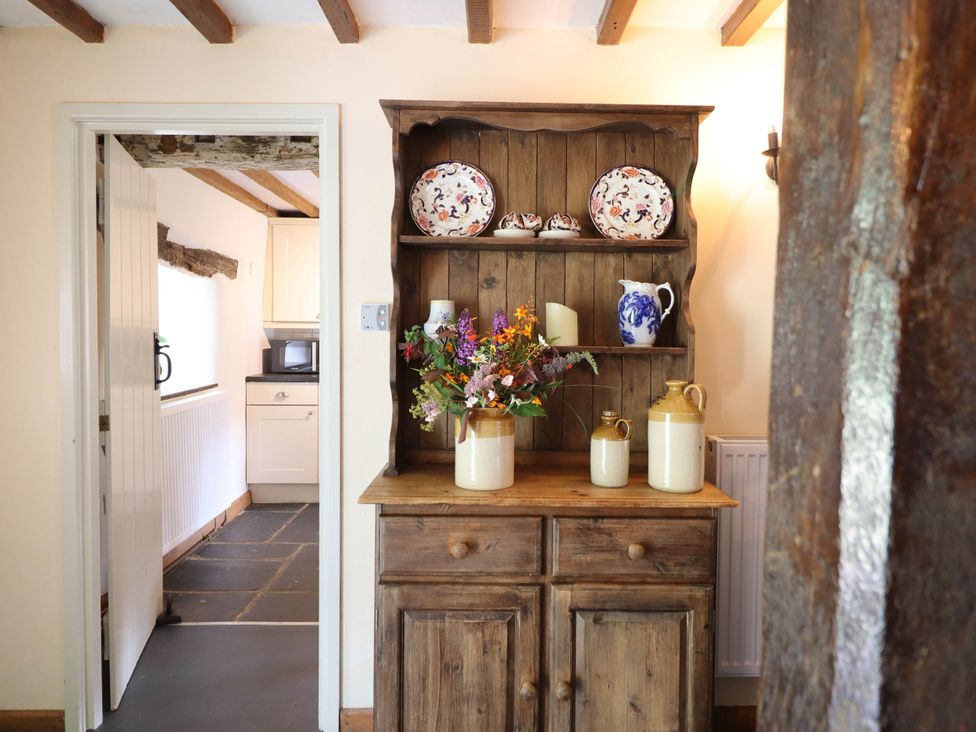 A cupboard with flowers and jugs in the kitchen at Frondirion in Dinas Mawddwy