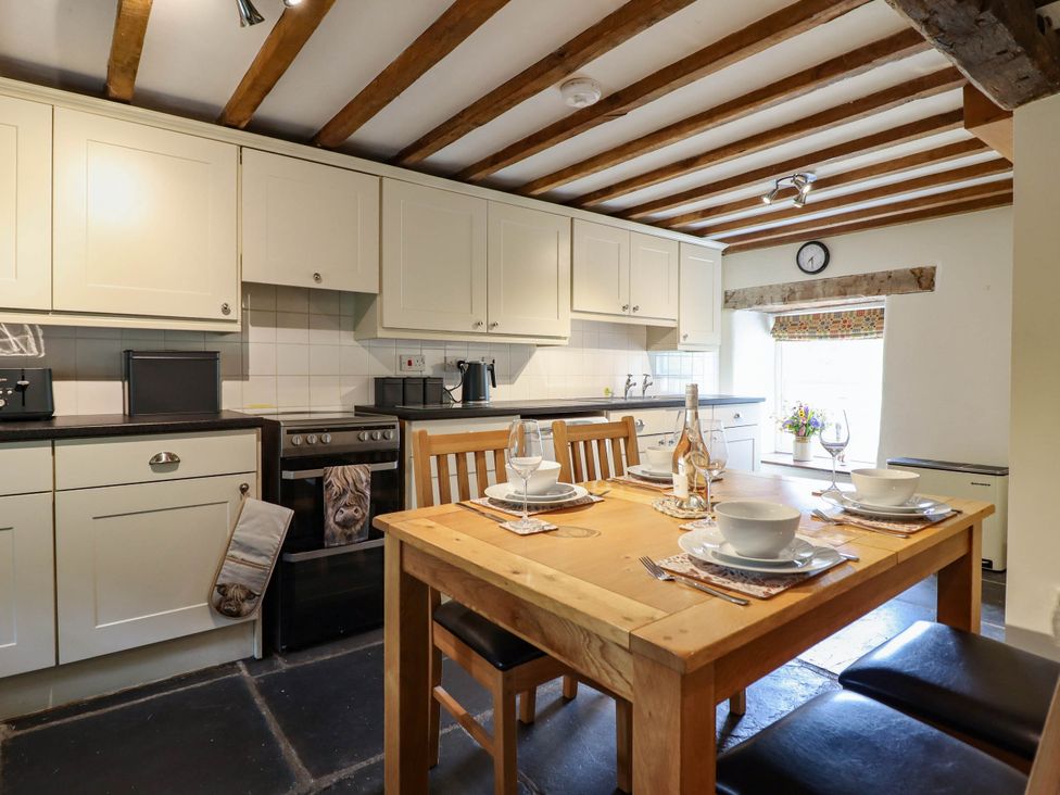 A kitchen with a dining table set at Frondirion in Dinas Mawddwy
