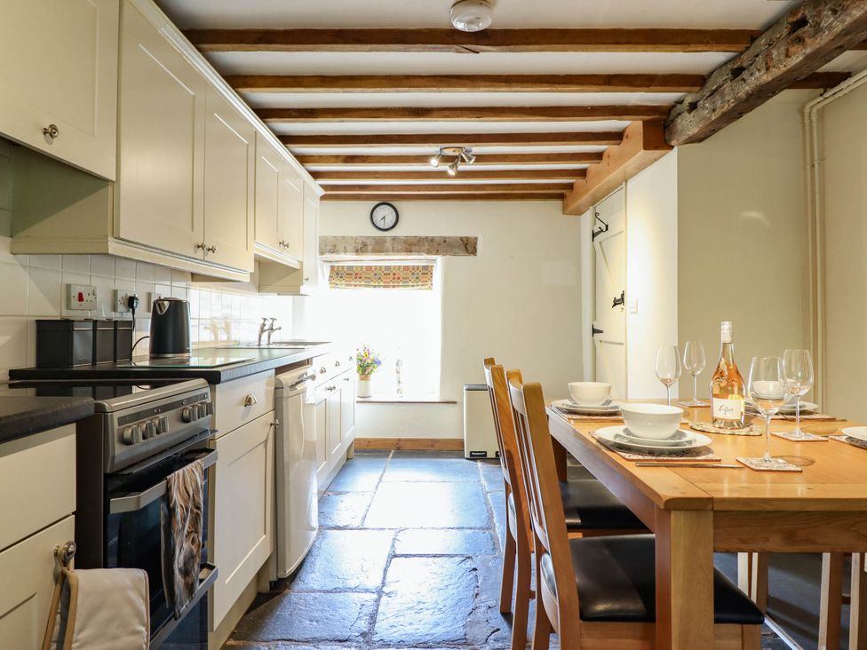 A kitchen with a dining table and chairs at Frondirion in Dinas Mawddwy