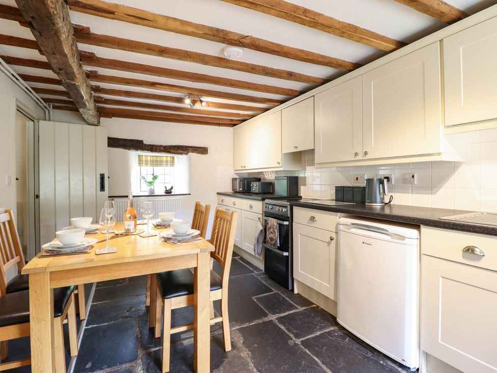 A kitchen with a dining table and chairs at Frondirion in Dinas Mawddwy