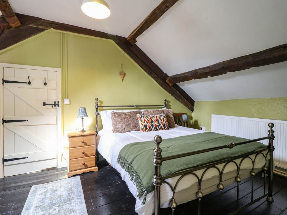 A bedroom with a bed and nightstand at Frondirion Dinas Mawddwy