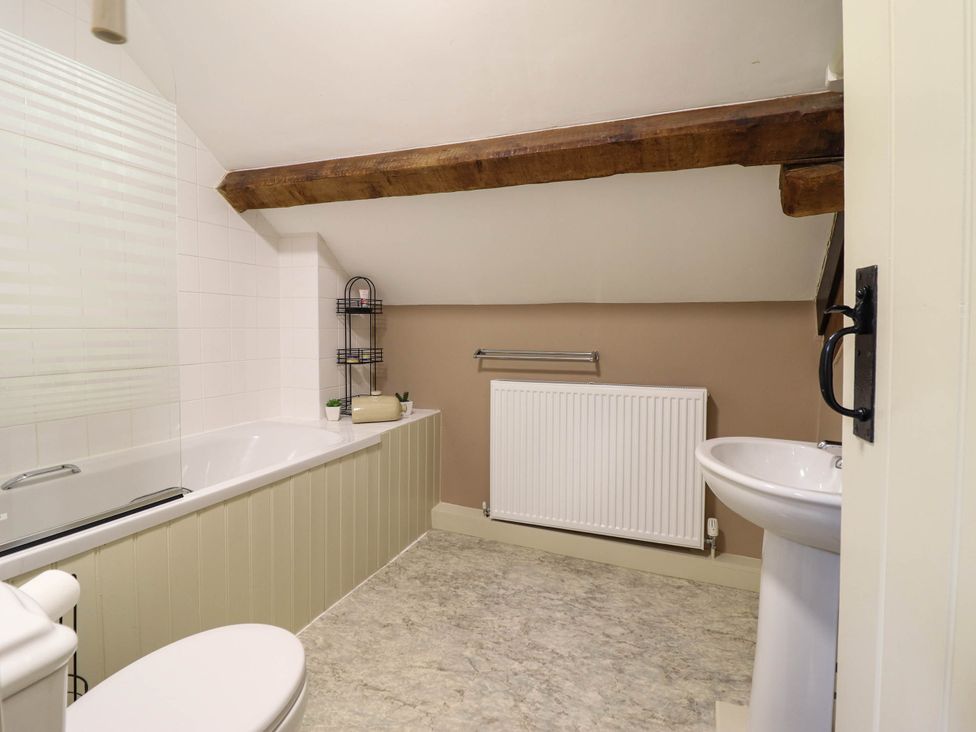 A bathroom with a bathtub and a washbasin at Frondirion Dinas Mawddwy