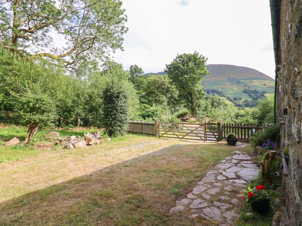 A garden view with a gate and trees at Frondirion in Dinas Mawddwy