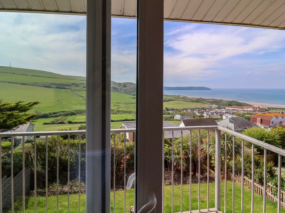 A view of the coastline and green hills from a balcony at 15 Chichester Park
