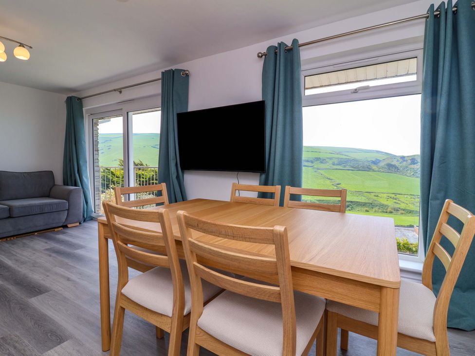 A dining area with a table and chairs and a television at 15 Chichester Park