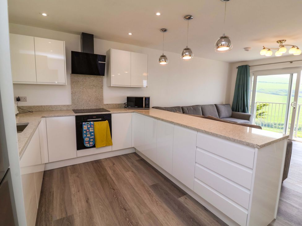 A kitchen with cabinets and a counter with a stove and microwave at 15 Chichester Park
