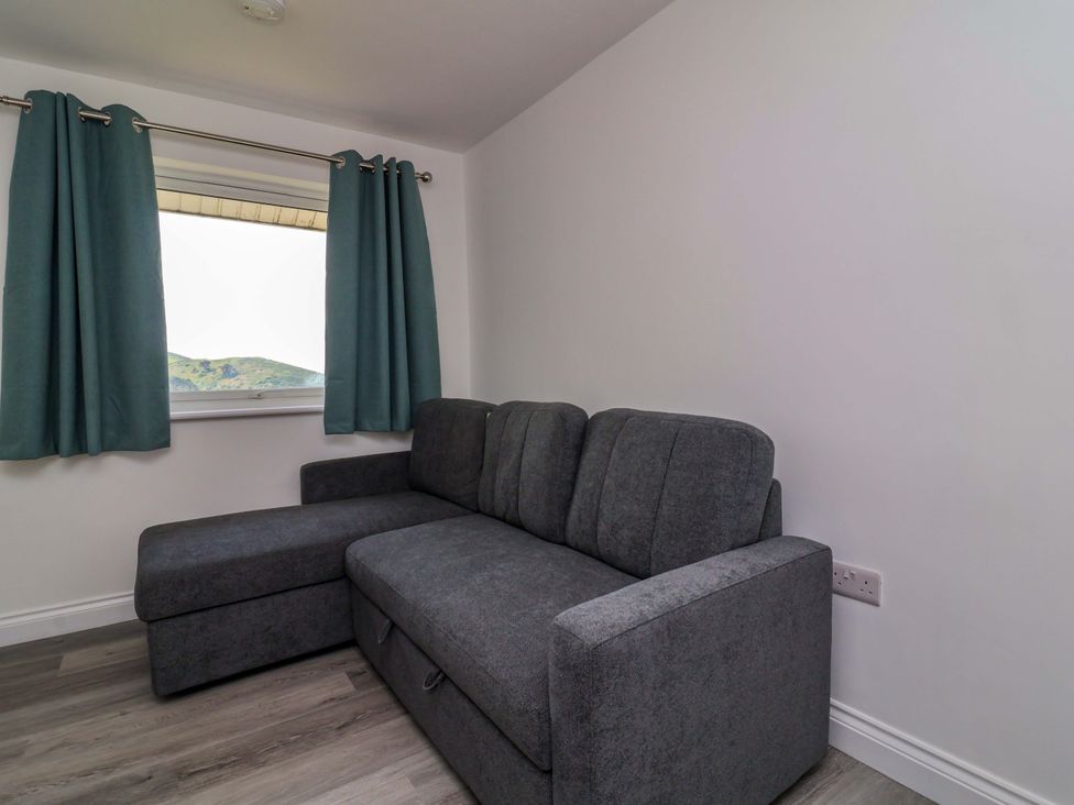 A living room with a sofa and window at 15 Chichester Park