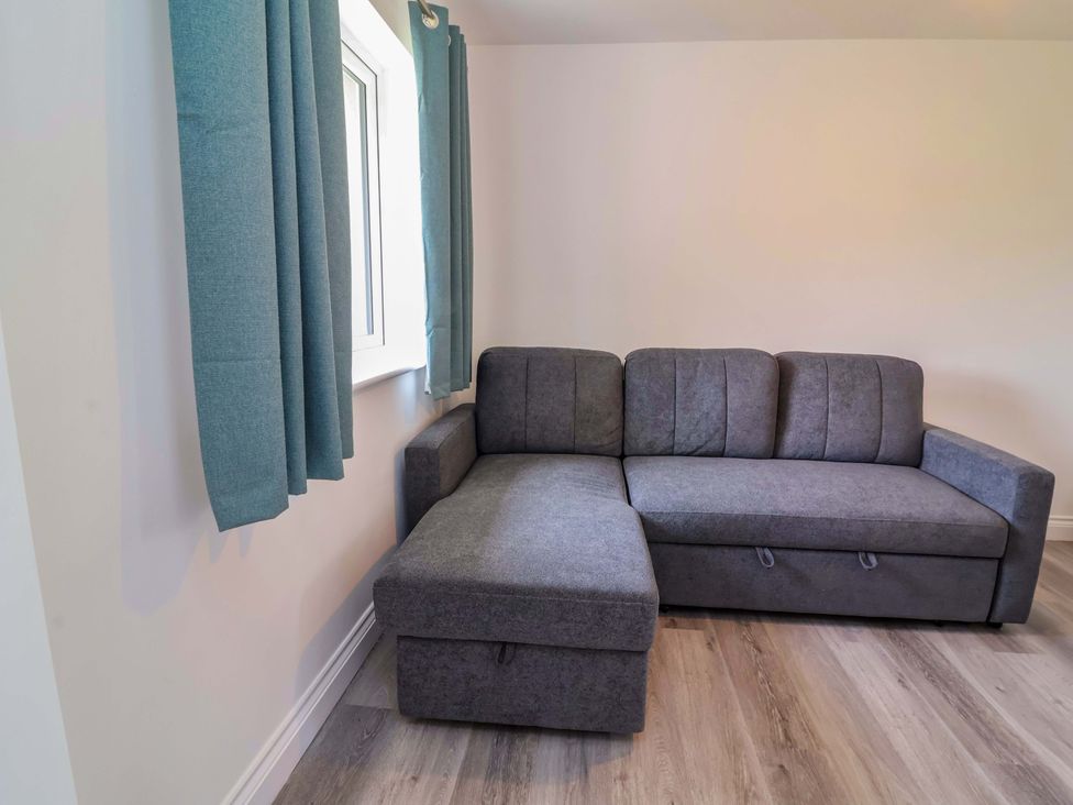 A living room with a sofa and window at 15 Chichester Park