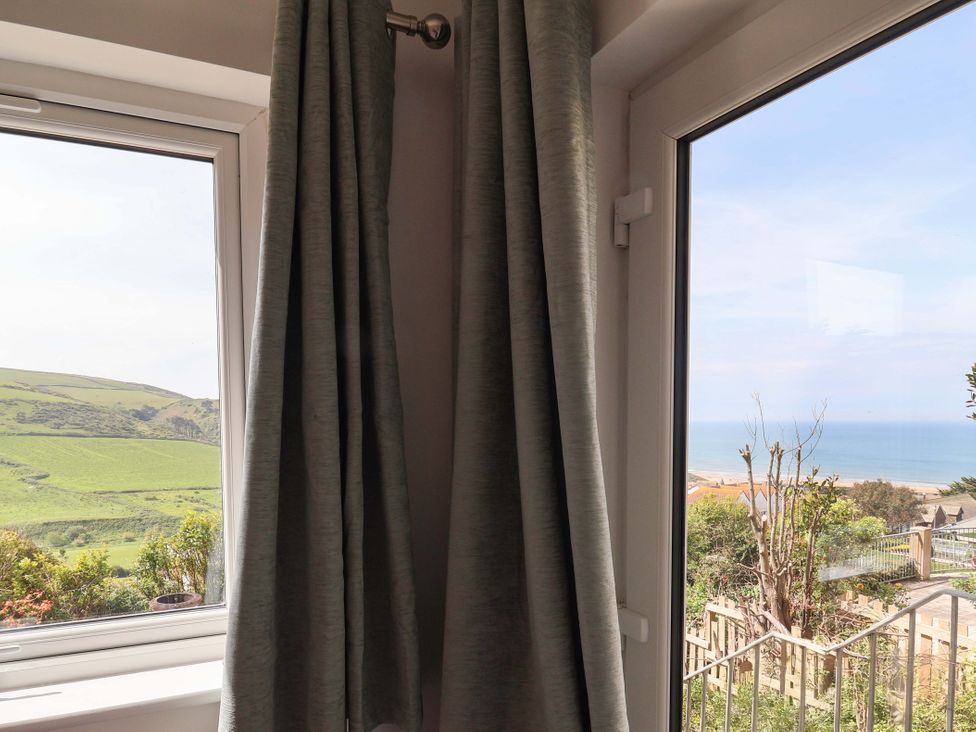 A window with curtains and a view of the sea and landscape at 15 Chichester Park